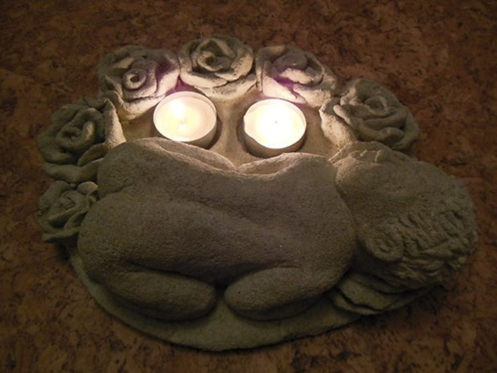 Svícnová soška spící miminko v růžích